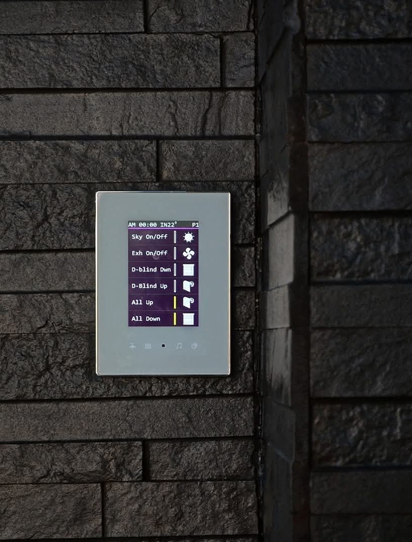 A touch panel mounted on a stone wall, controlling skylights, extraction and blinds